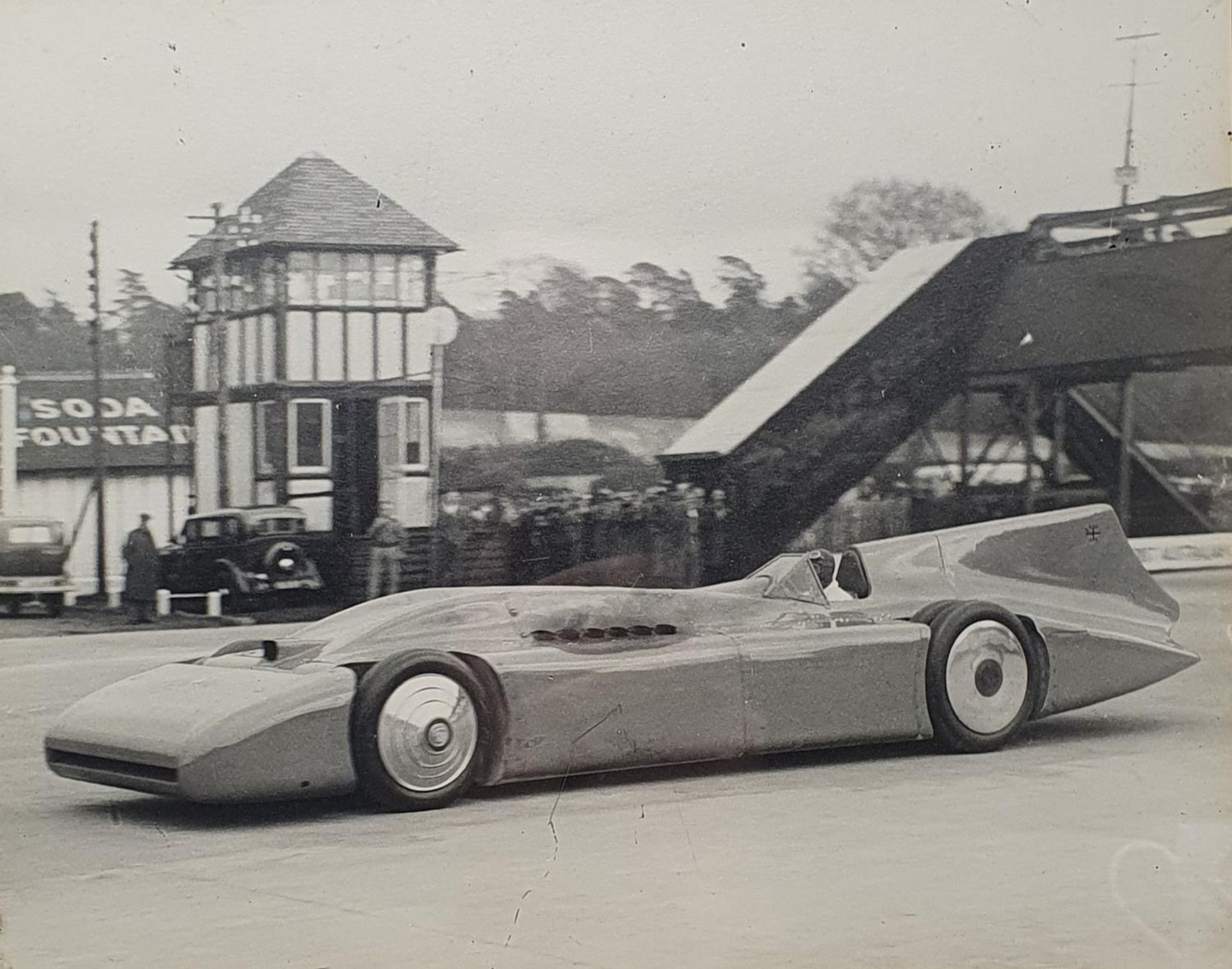 An Autocar monochrome photograph of Sir Malcolm Campbell at the wheel of Bluebird, 23.5 x 29 cm, and - Image 2 of 2