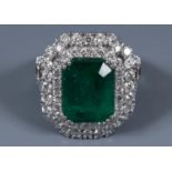 An 18ct white gold, emerald and diamond double halo ring, with diamond shoulders, ring size J½