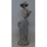 A Lladro figure, of a woman holding a cup and saucer, 36 cm high Overall condition good no chips