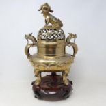 A Chinese polished bronze censer and pierced cover, with a Shi Shi dog finial, the base with