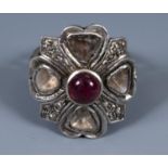 A white metal ring, with a central tourmaline cabochon surrounded by diamond set shaped panels, in a