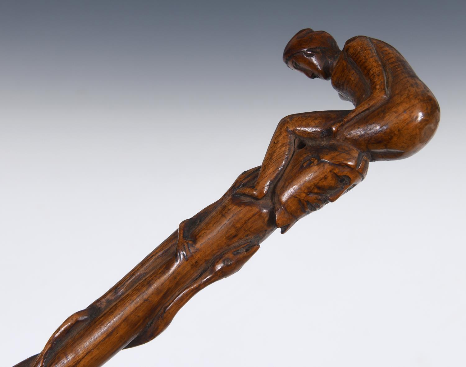 A 19th century folk art walking stick, the handle carved in the form of a naked woman crouched