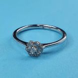 An 18ct white gold and diamond daisy style ring, ring size J½