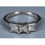 An 18ct white gold and three stone princess cut diamond ring, ring size L