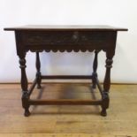An oak lowboy, with a carved drawer, on turned legs united by a stretcher, 82 wide