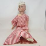 A bisque head doll, with sleeping blue eyes and open mouth with four teeth, impressed C M