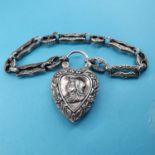 A modern silver coloured metal Albertina chain, with a heart shaped lock embossed with portrait