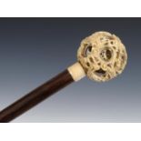 A 19th century walking stick, with a carved Chinese puzzle ball handle, on a hardwood shaft, 89 cm
