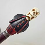 An Early 20th century walking stick, with a carved ivory and wood handle in the from of a skull