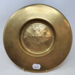 A 17th century style brass charger, embossed a queen, 28 cm diameter