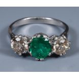 An 18ct white gold and three stone emerald and diamond ring, ring size approx. L