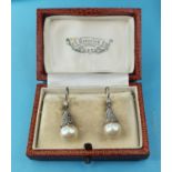 A pair of early 20th century pearl and diamond drop earrings One with small chip near mount RB