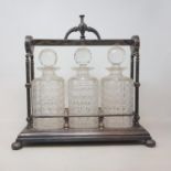 A 19th century silver plated three bottle tantalus, glass chipped, 37 cm wide One decanter