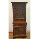 An early 20th century oak bookcase on cabinet, the top with two stained glass leaded glazed doors,