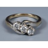An 18ct white gold three stone diamond crossover ring, ring size H