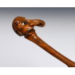 A 19th century folk art walking stick, the handle carved in the form of a grotesque figure, 89 cm