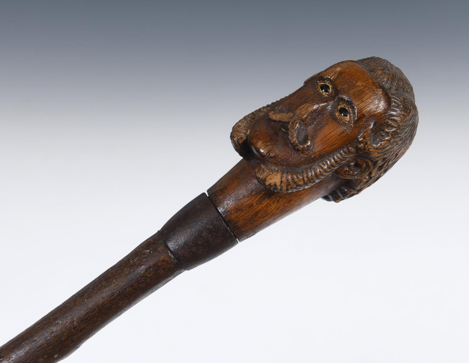 An early 20th century folk art cane, the handle carved in the form of a gentleman with a