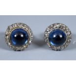 A pair of cabochon sapphire earrings, set with a surround of diamonds