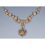 An Edwardian 9ct gold and pearl pendant necklace, in the form of vine leaves and flowers, with a