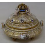 A Continental porcelain tureen, with a crown handle flanked by two putti, highlighted in gilt,
