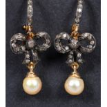 A pair of diamond set earrings, with cultured pearl drops RB Top of bow to bottom of pearl approx.