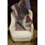A 1920's armchair, and three red ground rugs (4)