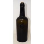 A late 18th/early 19th century green glass wine bottle, applied a seal, 28 cm high Small chip to