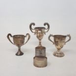 Three small silver trophy cups, and two silver napkin rings, 8.7 ozt