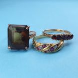An 18ct gold, diamond and garnet ring, a 9ct gold and garnet ring, and a cocktail ring (3) Report by