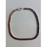 An 18ct white gold multi-coloured 'rainbow' sapphire bracelet, designed as a row of 37 claw set