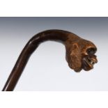 A 19th century bamboo walking stick, the handle carved in the form of a monkey, with glass eyes
