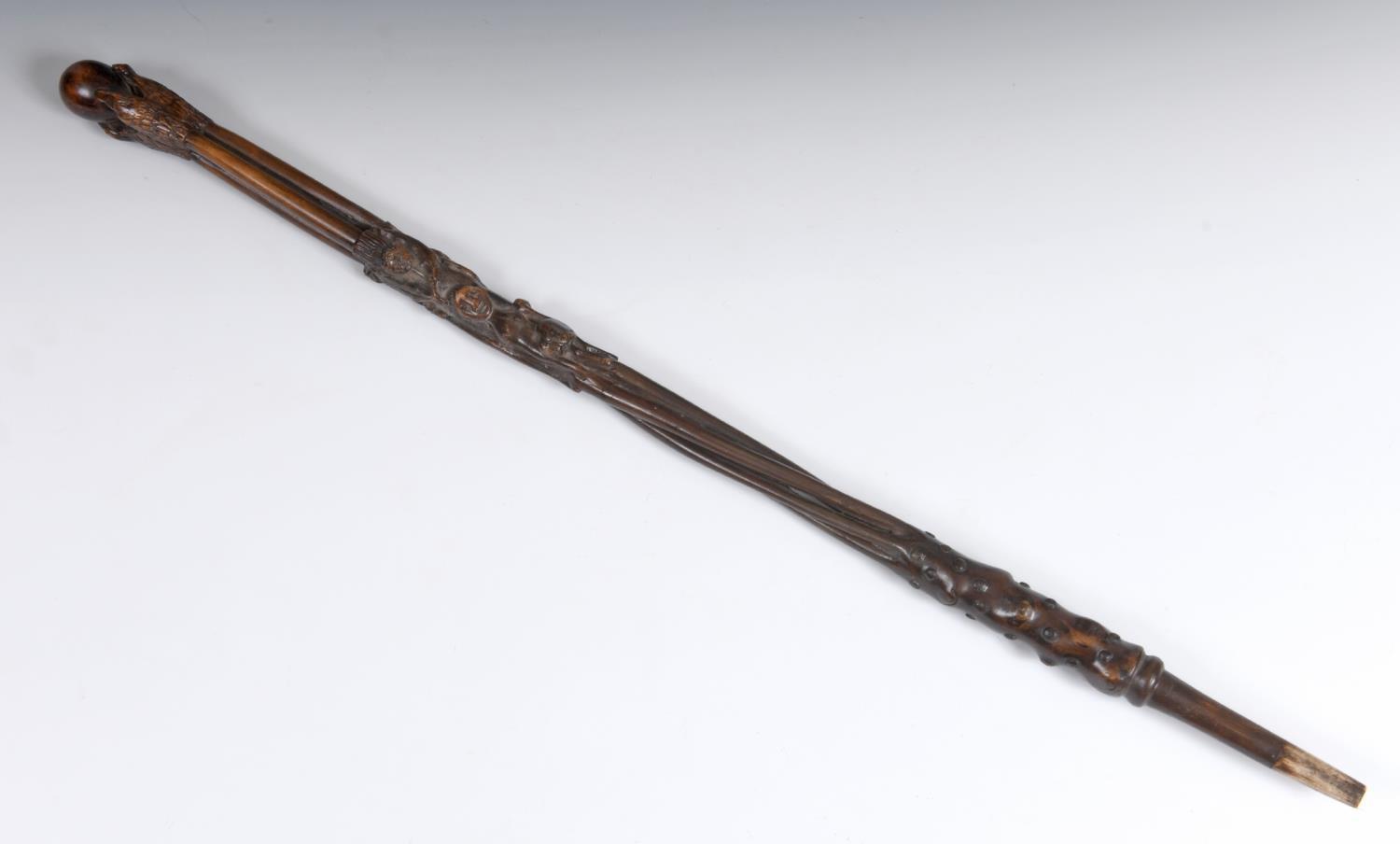 A 19th century folk art walking stick, the handle carved in the form of a talon gripping an egg,