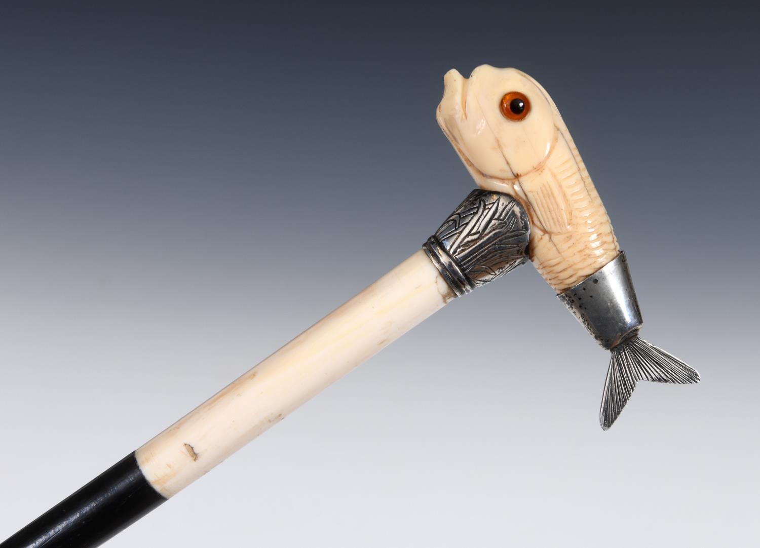 A 19th century walking stick, with a carved ivory handle in the form of a fish, with a white metal