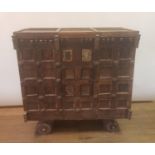 An Eastern carved hardwood marriage chest, with a cupboard door, on four wheels, 130 cm wide