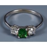 An 18ct gold three stone ring, the green stone flanked by two diamonds, ring size O