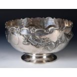 A large Chinese silver coloured metal pedestal bowl, with a wavy rim above a border embossed in high