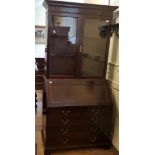 An early 20th century mahogany bureau bookcase, the top with two glazed doors, above fall front with