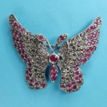 A modern silver coloured metal butterfly brooch, inset with red and white stones, 5 cm wide Report