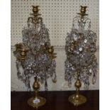 A pair of brass and cut glass candelabra, with upper nozzle above four scroll branches, each hung