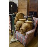 A wing back armchair, two bookcases, two wicker elephant stands, a pole screen converted to a