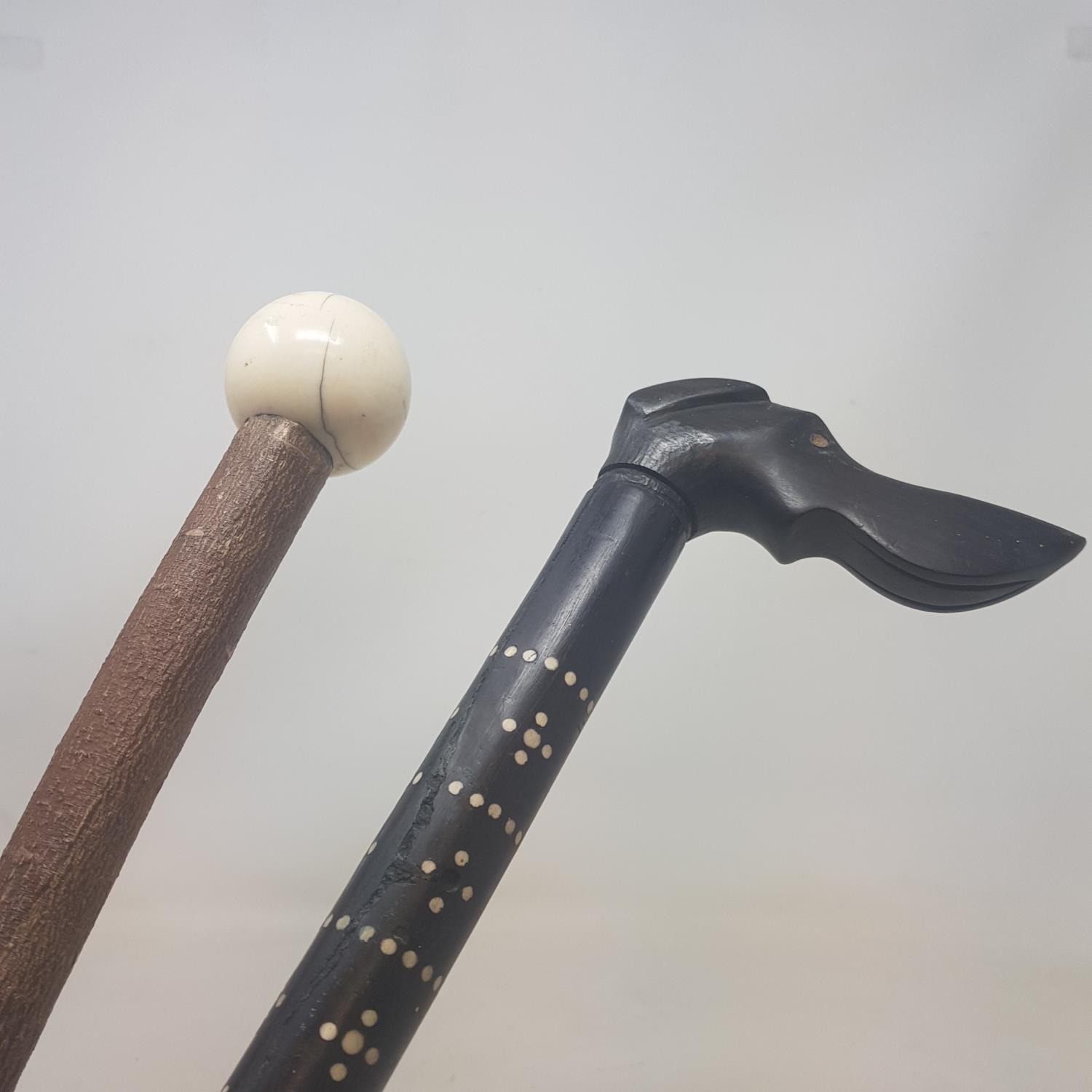 An early 20th century walking stick, the handle carved in the form of a dog, the shaft with bone