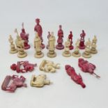 An early 20th century Chinese red and natural carved ivory chess set, incomplete
