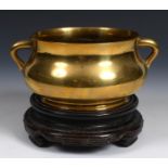 A Chinese bronze censer, six character mark to base, on a hardwood stand, 20 cm diameter Has been