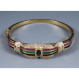 An 18ct gold bangle, set with a central sapphire, ruby, emerald and diamonds 23g ( all in)