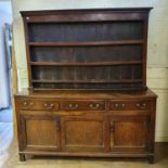 An 18th/19th century oak dresser, the plate rack above three drawers and three cupboard doors, 174