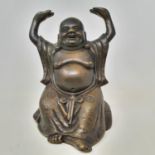 A Chinese bronze figure of a seated Buddha, with his hands held up, wearing a robe with characters