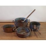 A 19th century brass and copper twin handled saucepan, 42 cm diameter, three other saucepans, and