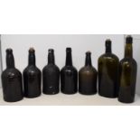 A 19th century green glass wine bottle, 30 cm high and six others (7) Bottle third from right, small