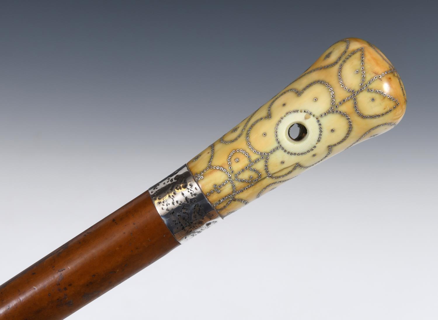 A late 17th/early 18th century walking stick, with a carved ivory pique decorated handle, on a