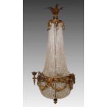 A gilt metal bag chandelier with cut glass drops, decorated with animal mask and festoons, 110 cm
